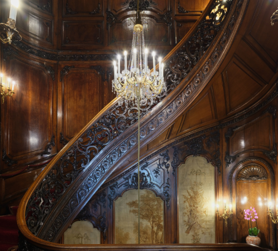 Intricately carved staircase in the historic interiors of Les Ambassadeurs